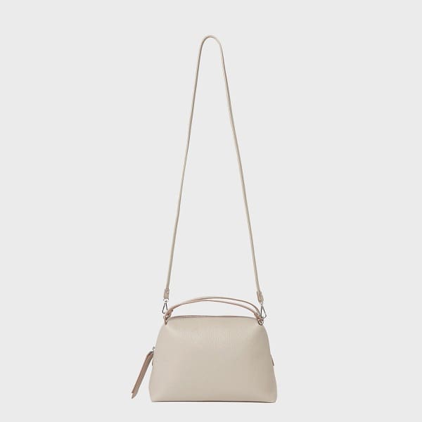 Le sac à bandoulière GIANNI CHIARINI ALIFA en cuir beige italien présente un design minimaliste, des bretelles réglables, des poignées courtes et un haut zippé.