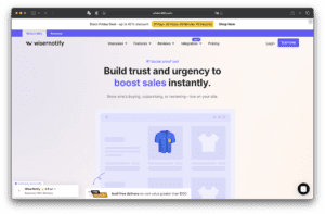 La page d’accueil du site de Wisernotify affiche un titre sur la construction de la confiance et l’amélioration des ventes, un menu de navigation en haut, une image de produit en chemise bleue et un graphique de la boutique en ligne.